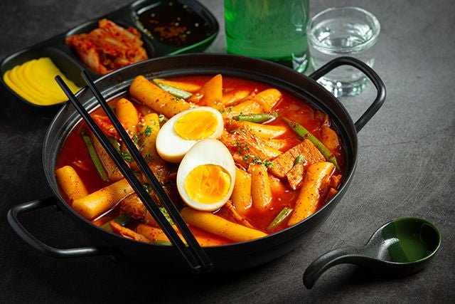 Cheesy Tokbokki korean traditional food on black board background. Lunch dish., Cheesy Tokbokki korean traditional food on black board backgroun